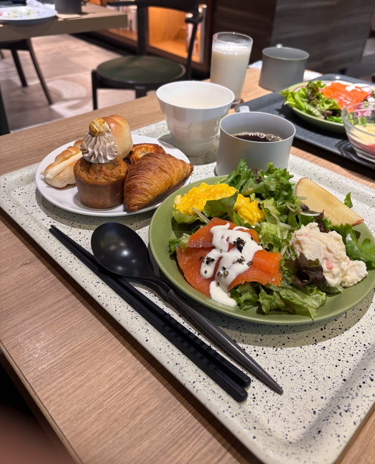 クロワッサンやマフィンなどのパン類とスモークサーモンのサラダを盛り合わせたOMO7旭川の朝食プレート