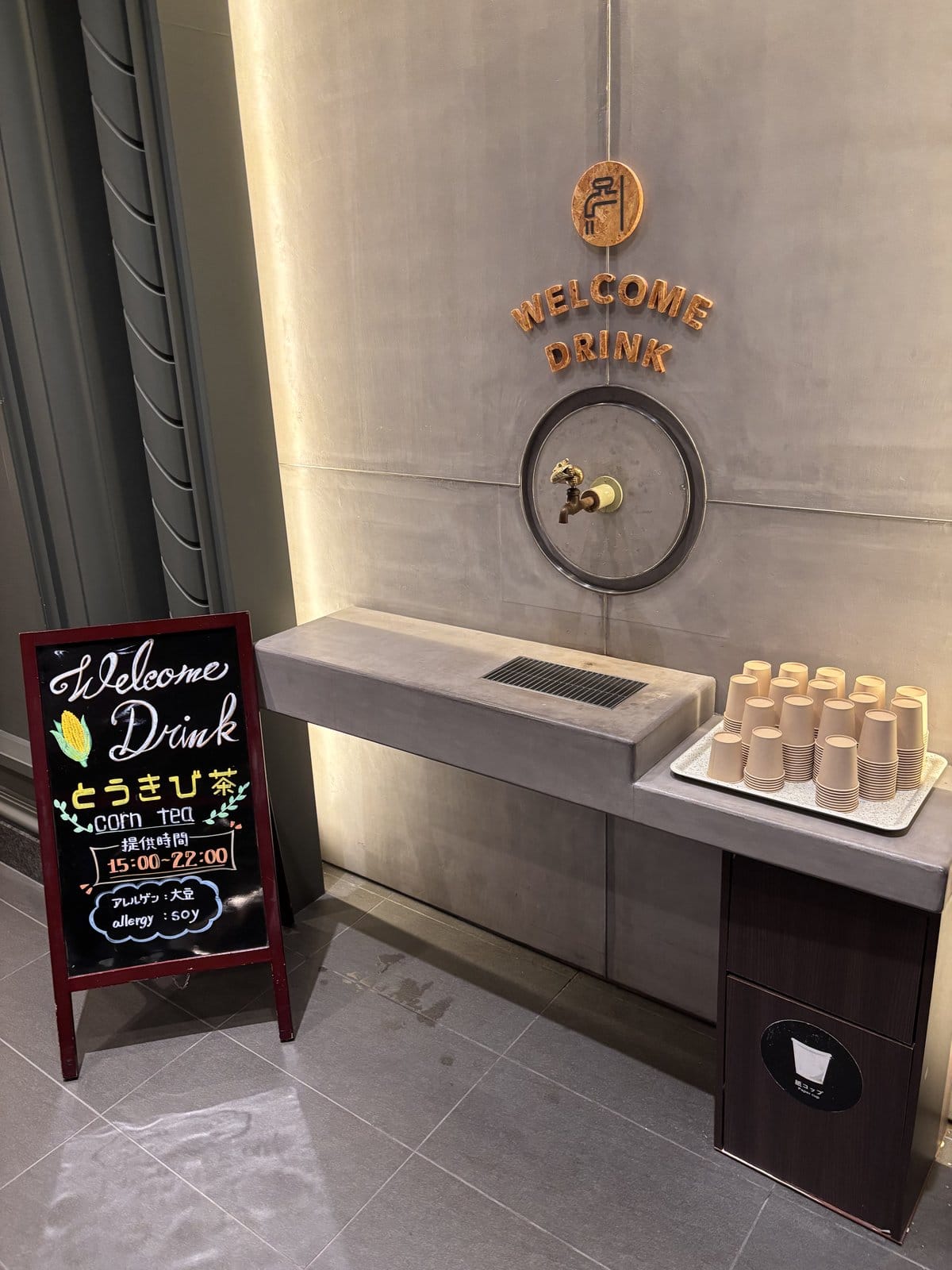 OMO7旭川のウェルカムドリンクであるとうきび茶のサーバーと案内看板