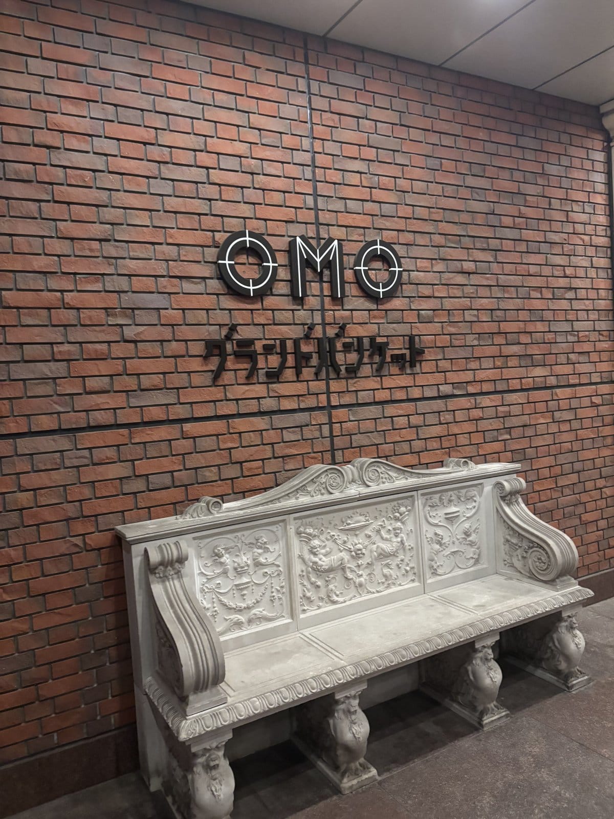 OMO7旭川の煉瓦造りの壁面とアンティーク調の白いベンチ