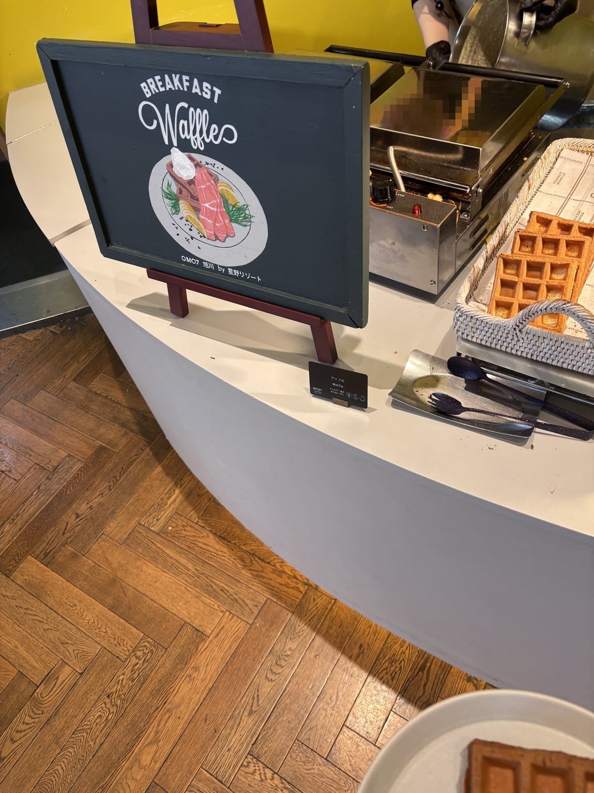 OMO7旭川の朝食ビュッフェにあるサーモンワッフルの看板と焼きたてワッフルのコーナー