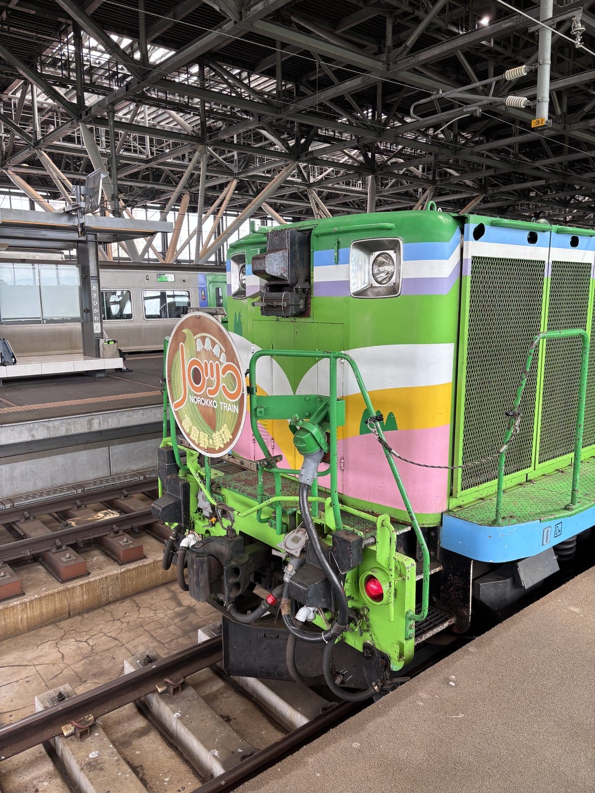 旭川駅のホームに停車する富良野・美瑛ノロッコ号の緑色のディーゼル機関車