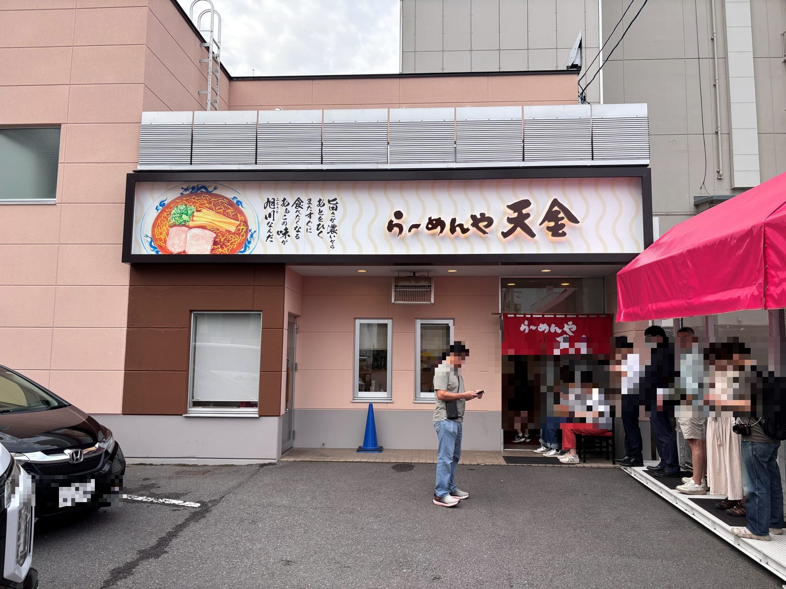旭川 らーめんや天金 四条店 外観と入口前の行列