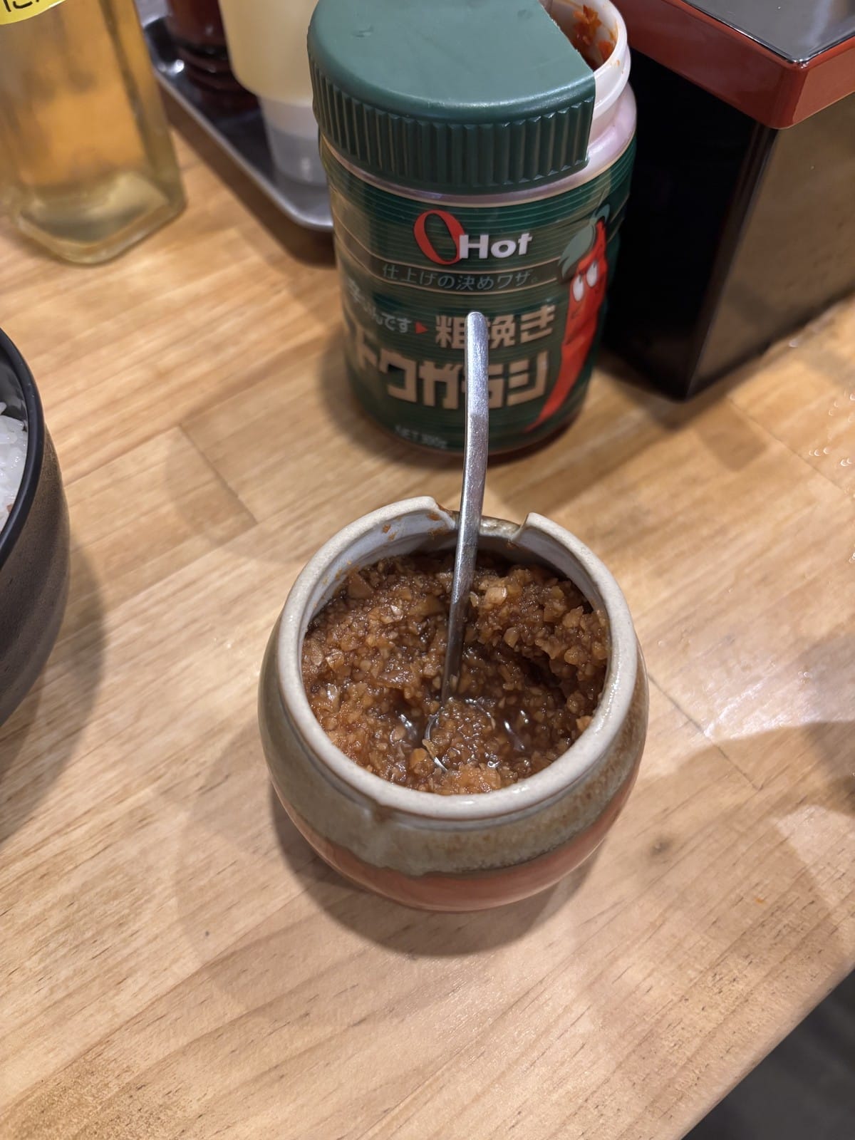 壺に入ったニンニク醤油漬けにスプーンが刺さっている様子