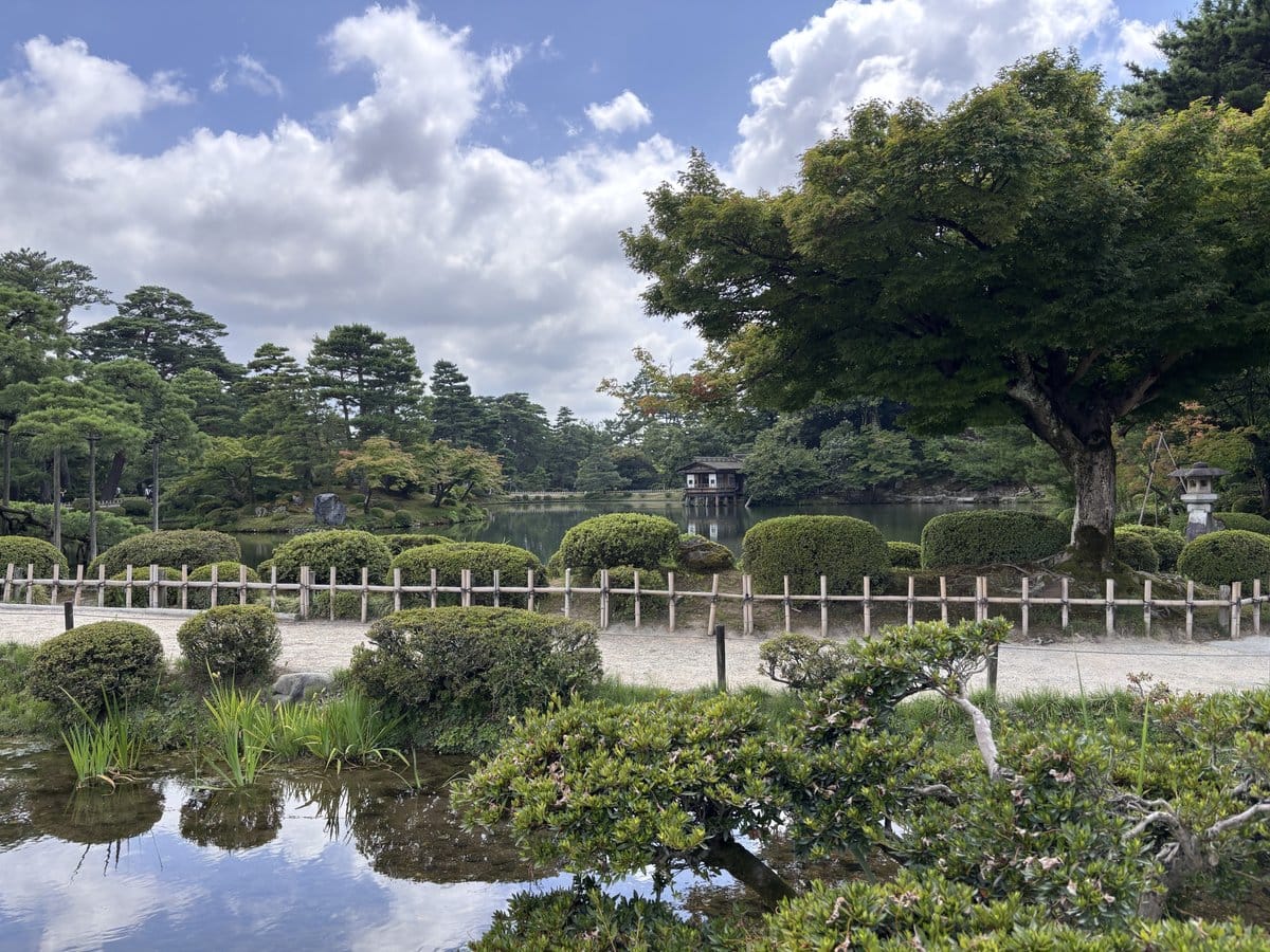 兼六園の霞ヶ池と水上に建つ内橋亭、周囲を囲む松と緑