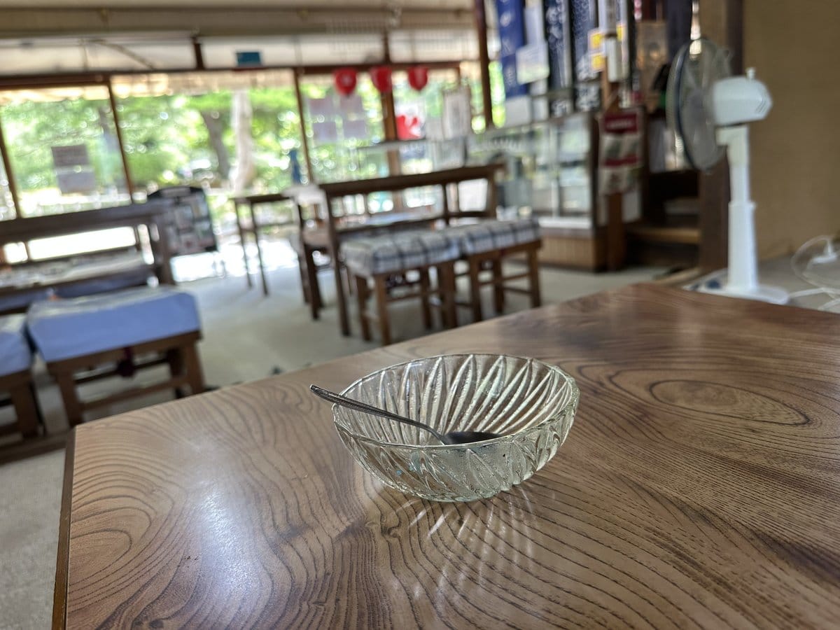 兼六園内のお茶屋さんの店内、テーブル席や扇風機、奥に見える緑の景色