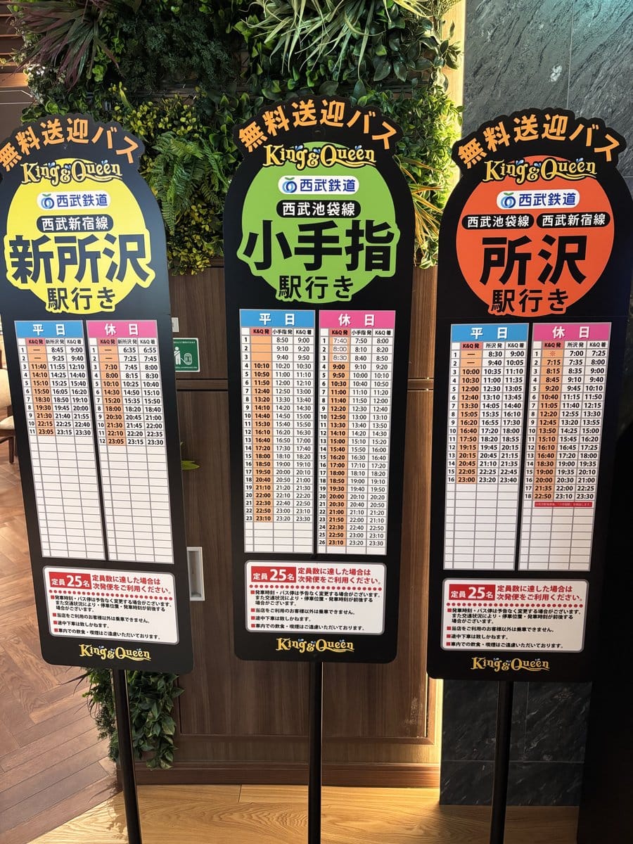 温泉バルコニー キング&クイーンの無料送迎バス時刻表。新所沢駅・小手指駅・所沢駅の3方向の発着時刻が書かれた案内板
