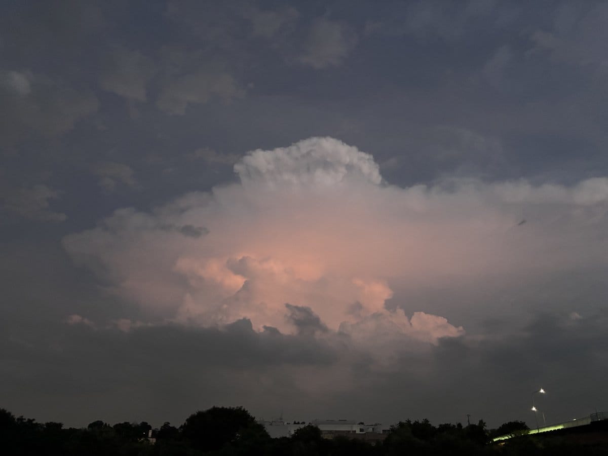 花火大会の開始前、オレンジ色の夕焼けに染まる大きな積乱雲