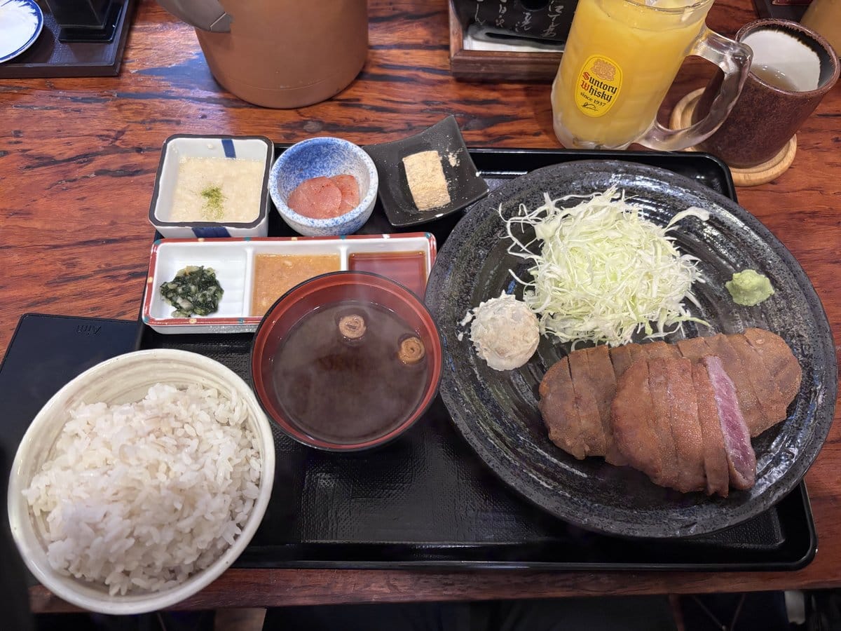 牛かつ定食一式、ご飯と赤味噌の味噌汁、小鉢3種、レアな牛かつが並ぶトレー