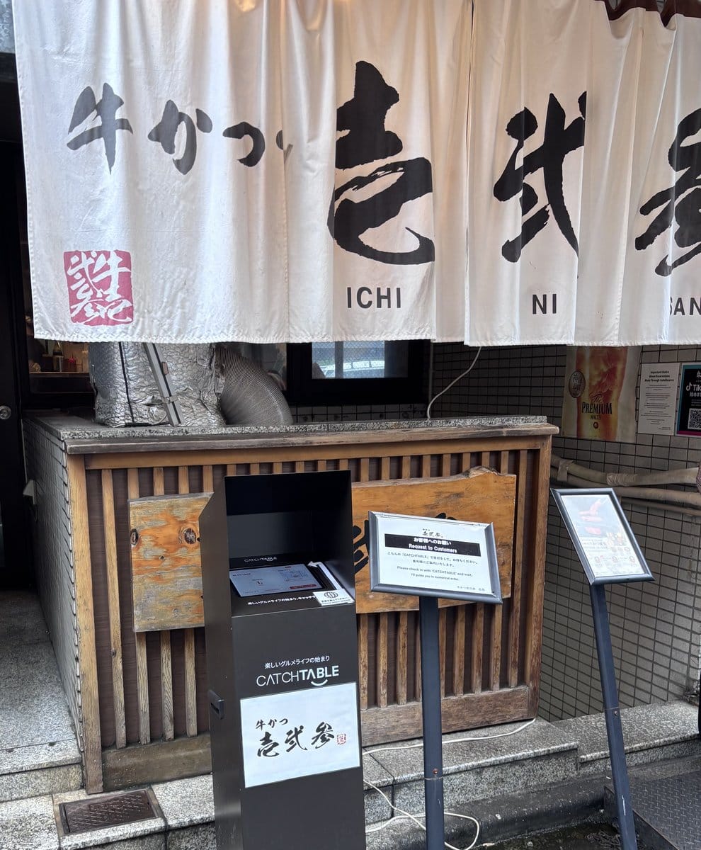 牛かつ壱弐参の店舗入口ののれんと受付機