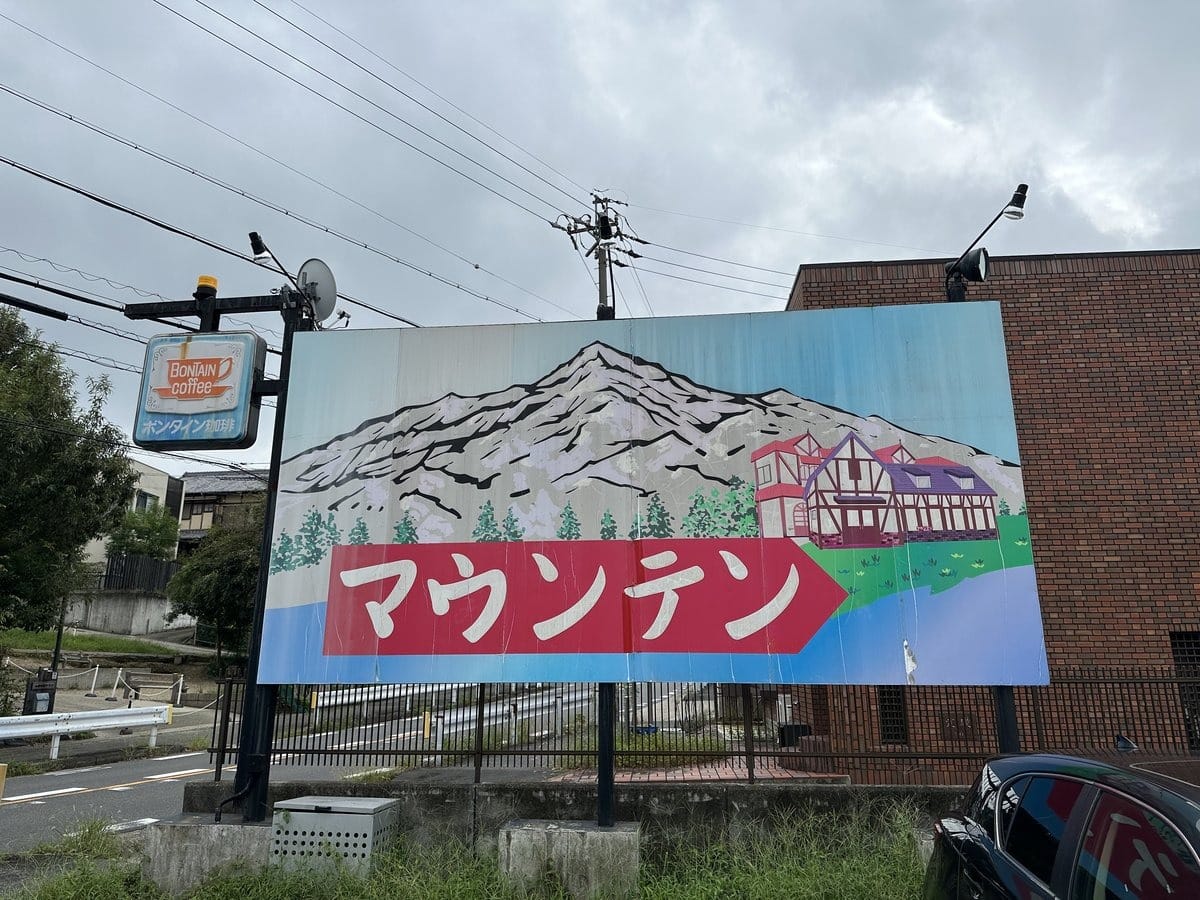 喫茶マウンテンの雪山のイラストが描かれた道路沿いの看板