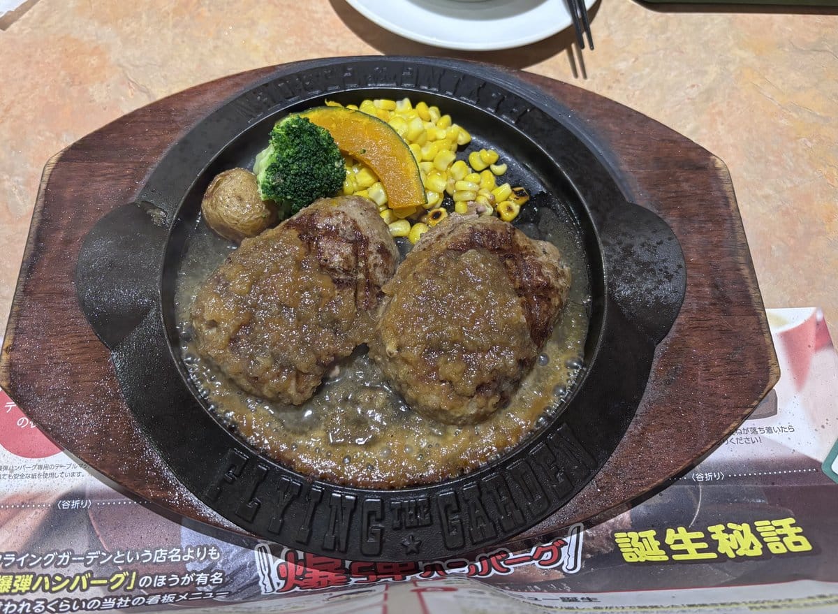 フライングガーデンの爆弾ハンバーグ 和風ソース 鉄板にのった切り分け済みのハンバーグ