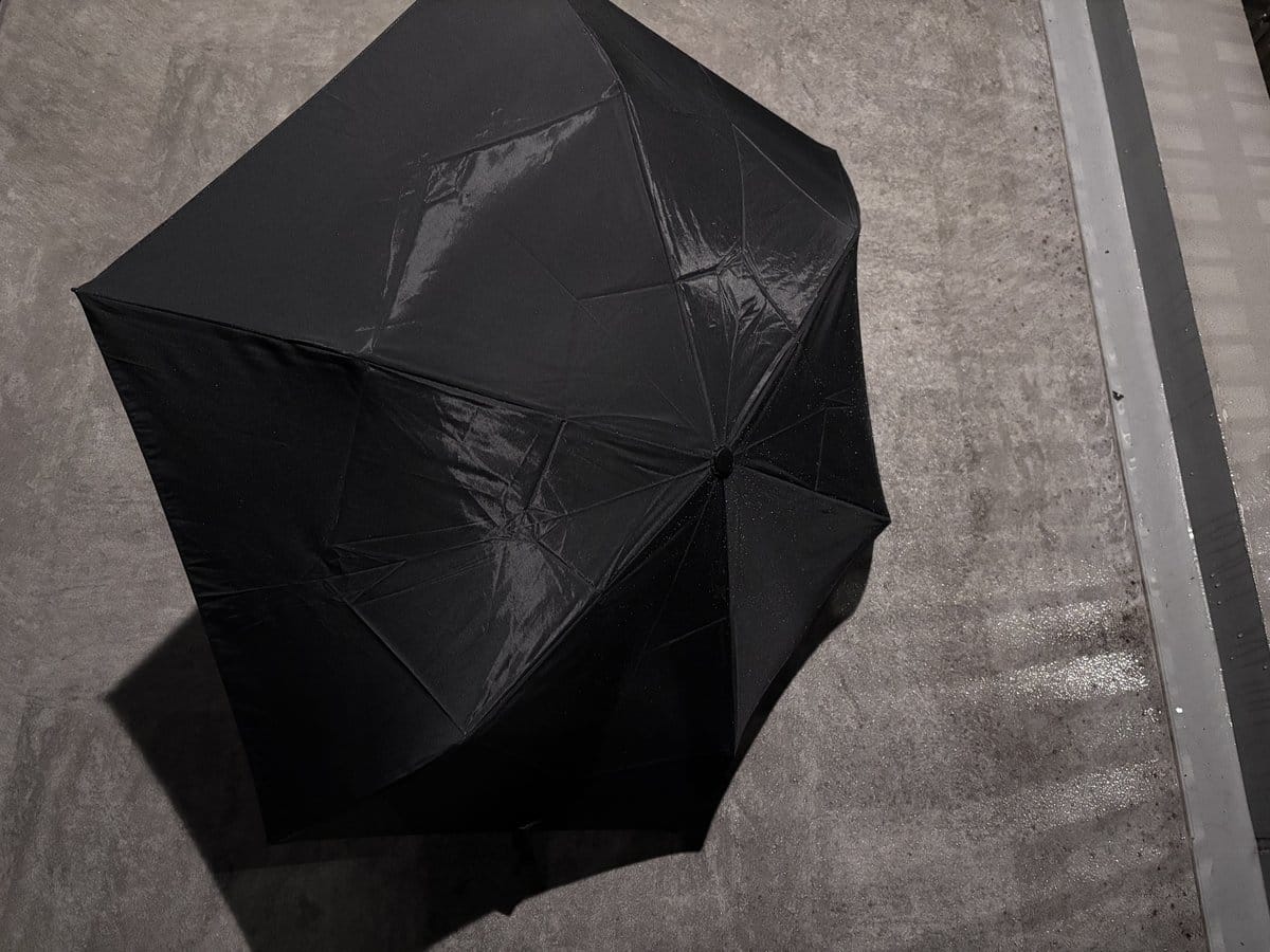 雨に濡れた地面の上に広げたSelfold Operaの外側。生地の水滴が少ない